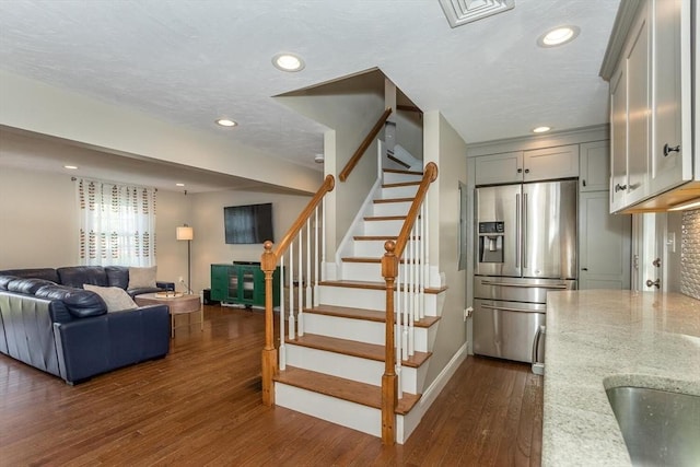 staircase featuring recessed lighting, baseboards, and wood finished floors