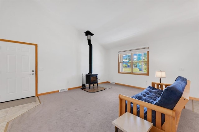 16 Amherst St, Chicopee, MA 01013 - living area with carpet, a wood stove, and vaulted ceiling