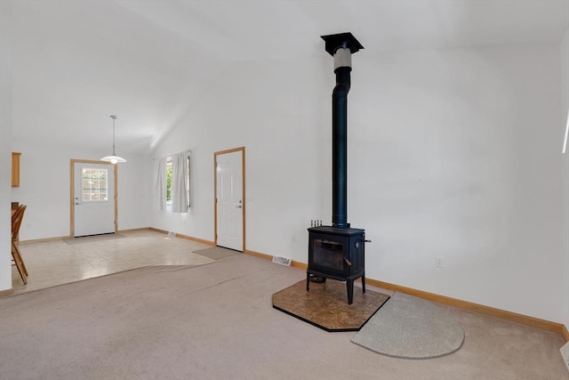 16 Amherst St, Chicopee, MA 01013 - unfurnished living room with a wood stove, vaulted ceiling, and carpet floors