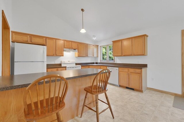 16 Amherst St, Chicopee, MA 01013 - kitchen with white appliances, under cabinet range hood, dark countertops, decorative light fixtures, and a kitchen breakfast bar