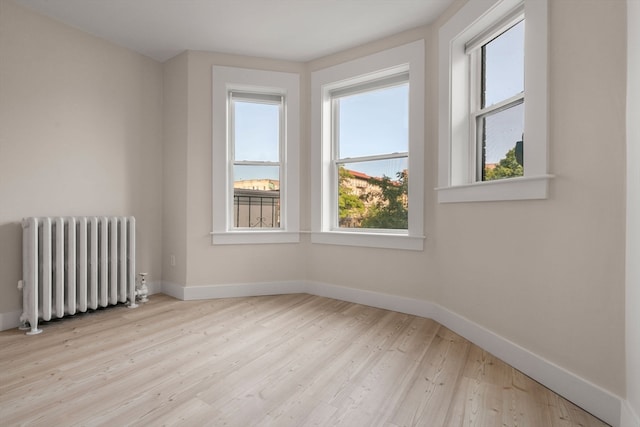 spare room featuring light hardwood / wood-style flooring and radiator heating unit