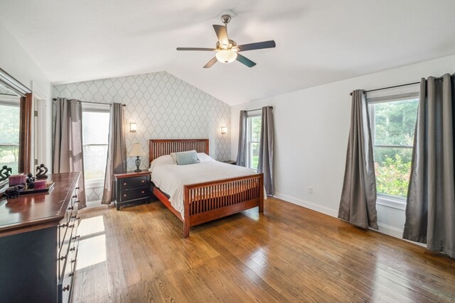 bedroom with ceiling fan, lofted ceiling, and hardwood / wood-style floors