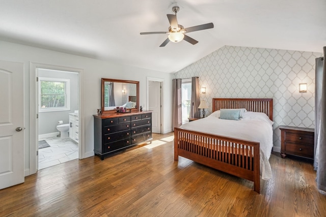 bedroom featuring vaulted ceiling, ceiling fan, ensuite bathroom, and hardwood / wood-style floors