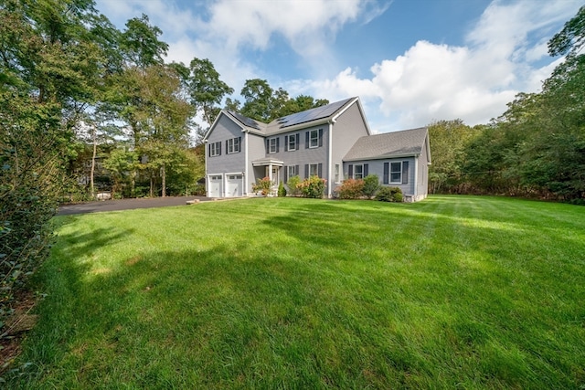 back of house featuring a lawn and a garage