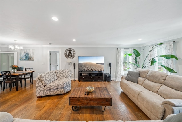 living room with ornamental molding, hardwood / wood-style flooring, and an inviting chandelier