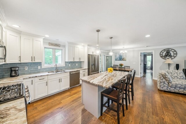 kitchen with a center island, dark hardwood / wood-style flooring, stainless steel appliances, and white cabinets