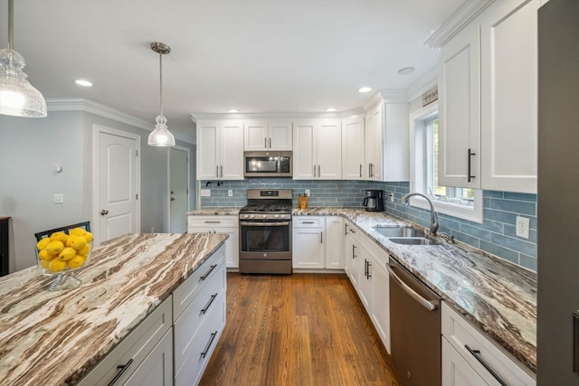 kitchen featuring pendant lighting, stainless steel appliances, and white cabinets