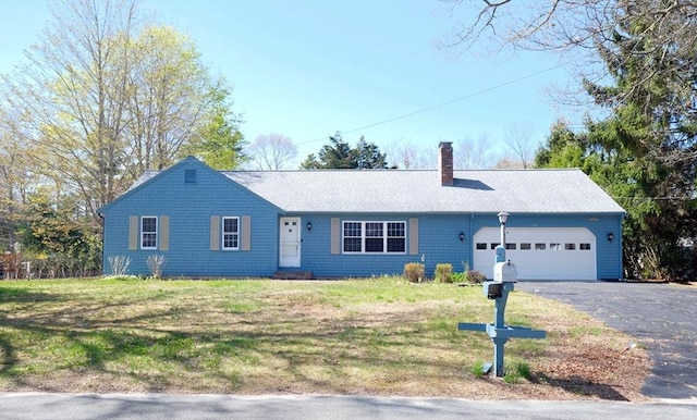 ranch-style house featuring a garage, a chimney, driveway, and a front lawn