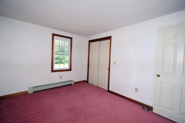 unfurnished bedroom featuring a closet, baseboards, a baseboard heating unit, and carpet flooring