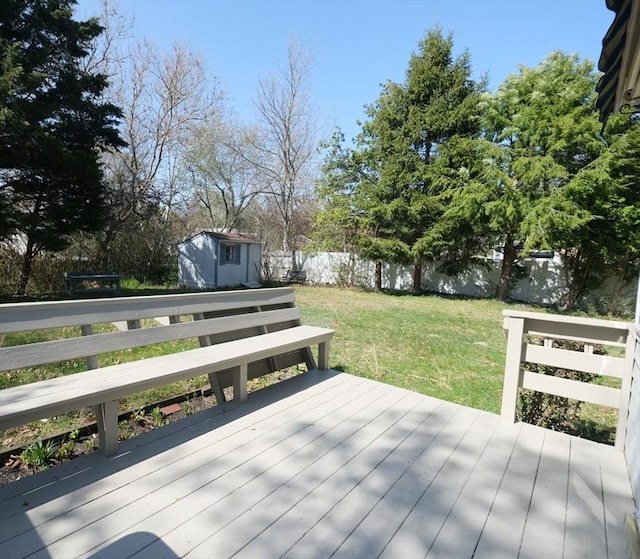 wooden terrace with a yard, an outbuilding, a shed, and a fenced backyard