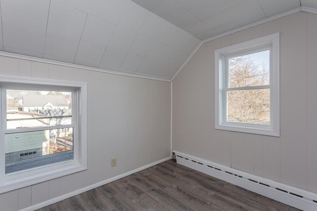 additional living space featuring vaulted ceiling, baseboard heating, wood finished floors, and baseboards