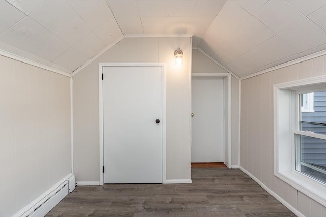 additional living space with a wealth of natural light, a baseboard heating unit, vaulted ceiling, and wood finished floors