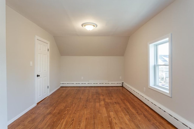 bonus room featuring vaulted ceiling, baseboard heating, and wood finished floors