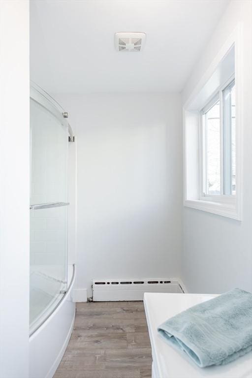 bathroom featuring visible vents, baseboard heating, and wood finished floors