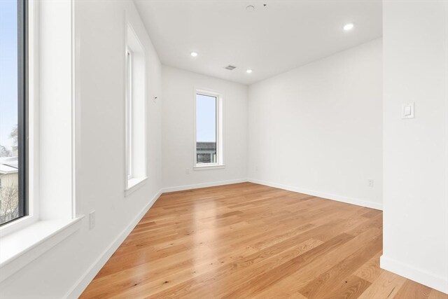 empty room featuring light wood-type flooring, recessed lighting, baseboards, and visible vents