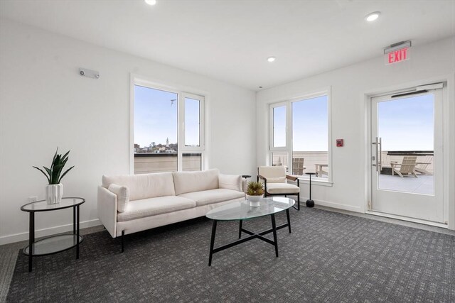 living room featuring dark carpet, recessed lighting, and a healthy amount of sunlight