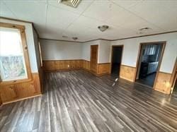 unfurnished room featuring dark wood-type flooring and wood walls