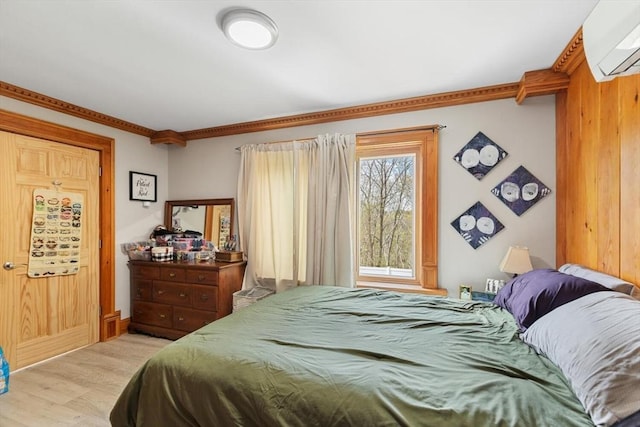 bedroom featuring light wood-style floors and a wall unit AC