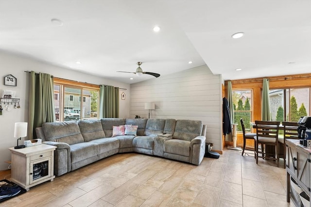 living room with vaulted ceiling, ceiling fan, wood walls, and recessed lighting