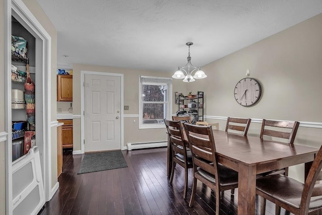 dining space featuring baseboard heating, dark hardwood / wood-style flooring, and an inviting chandelier