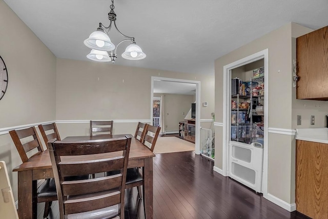 dining area featuring a notable chandelier and dark hardwood / wood-style flooring