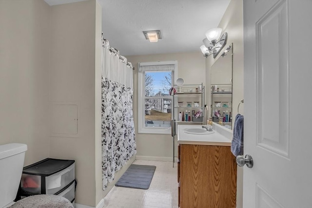 bathroom featuring a notable chandelier, vanity, toilet, and walk in shower