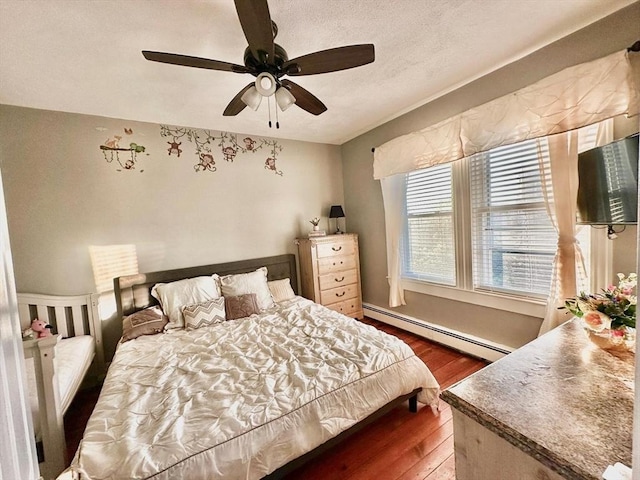 bedroom featuring a baseboard heating unit, dark wood-style flooring, and ceiling fan