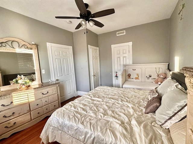 bedroom with dark wood finished floors, a ceiling fan, and baseboards