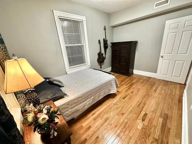 bedroom featuring light wood-style floors and baseboards