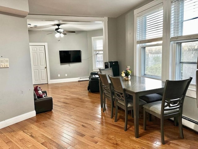 dining area with ceiling fan, light wood-style floors, baseboards, and a baseboard heating unit