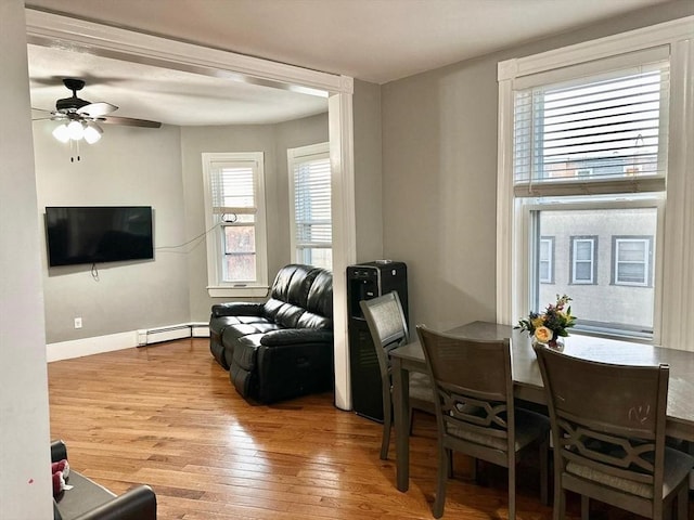 living room with a baseboard radiator, wood finished floors, ceiling fan, and baseboards