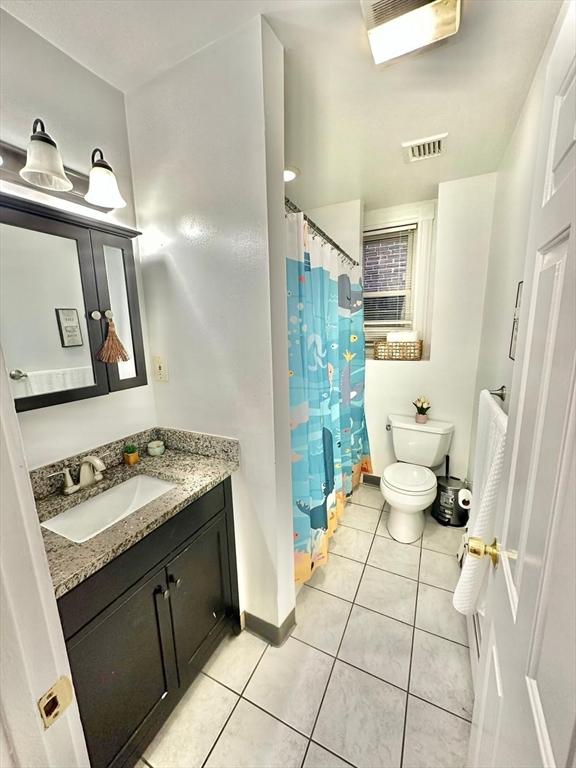 bathroom with toilet, tile patterned flooring, vanity, baseboards, and a shower with shower curtain