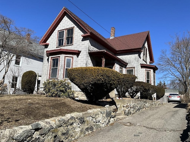 view of front facade featuring stone siding and a chimney