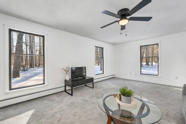 sitting room featuring baseboards, a ceiling fan, carpet, and a baseboard radiator