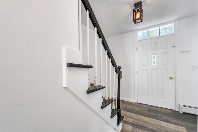 entryway with stairway, a baseboard heating unit, and dark wood-style flooring