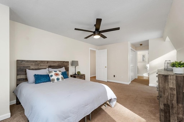 bedroom featuring a ceiling fan, carpet, baseboards, and a textured ceiling