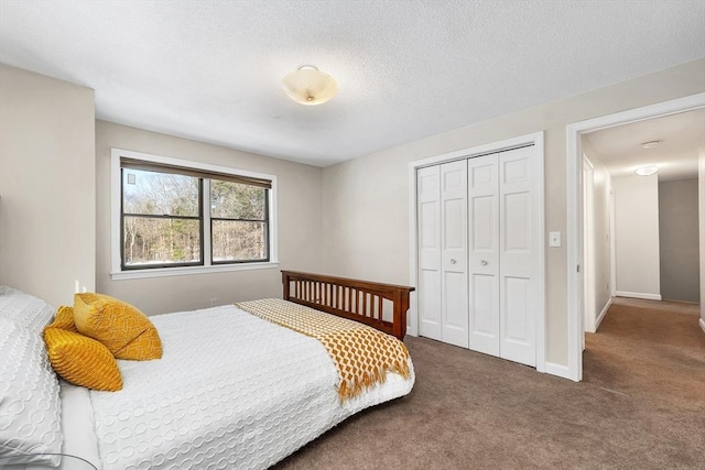 bedroom featuring a closet, a textured ceiling, baseboards, and carpet floors