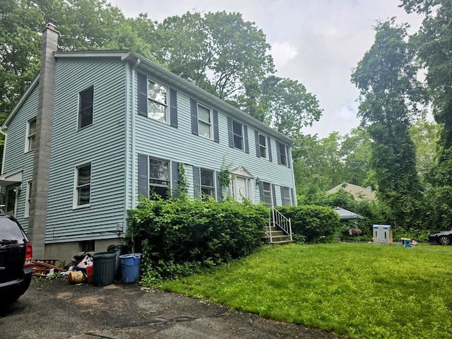 209-211 Ventura St, Ludlow, MA 01056 - colonial-style house with a chimney, a front lawn, and view of scattered trees