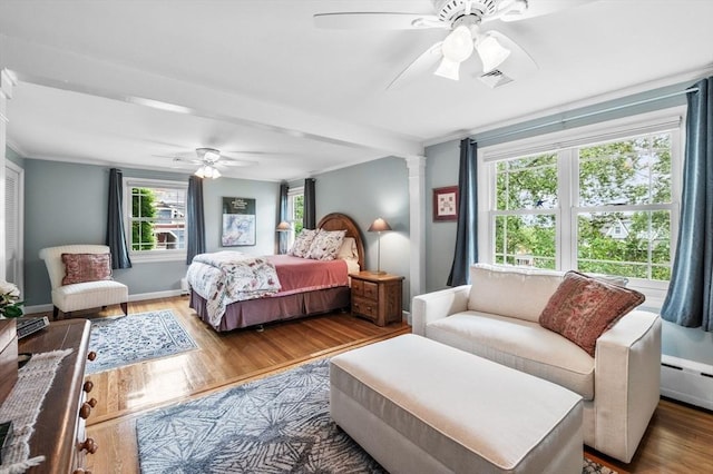 64 Pond St, Nahant, MA 01908 - bedroom with wood finished floors, crown molding, a ceiling fan, baseboard heating, and ornate columns