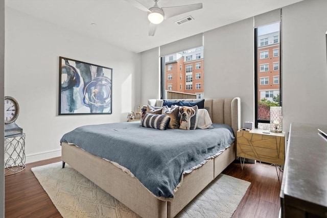 bedroom featuring dark wood-type flooring, ceiling fan, and multiple windows