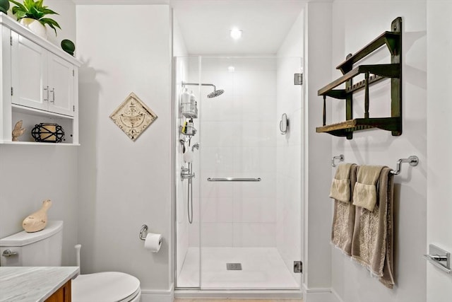 bathroom with walk in shower, vanity, and toilet