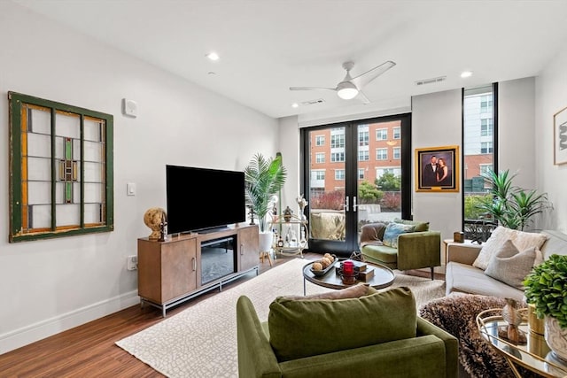 living room with hardwood / wood-style floors, ceiling fan, and french doors