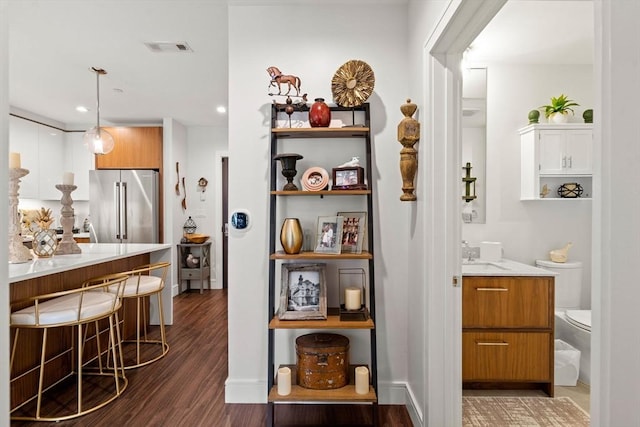 bar with pendant lighting, stainless steel fridge, dark hardwood / wood-style flooring, and sink