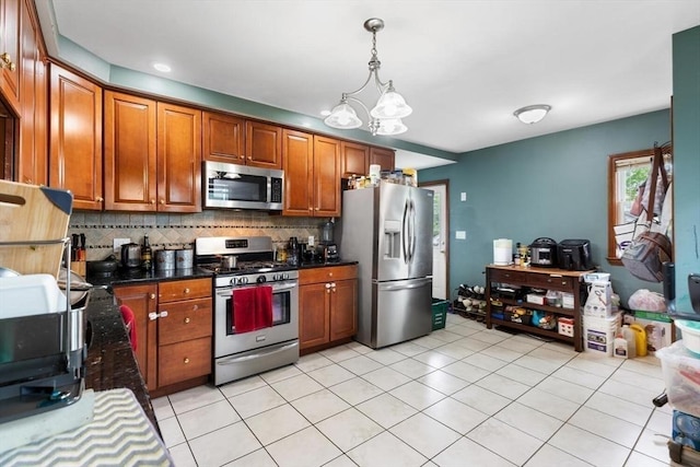 27-29 Waite St, Malden, MA 02148 - kitchen with appliances with stainless steel finishes, brown cabinetry, tasteful backsplash, hanging light fixtures, and a chandelier