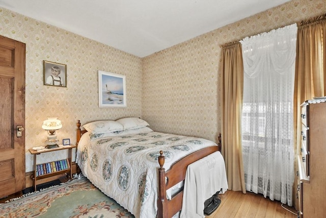 bedroom featuring hardwood / wood-style flooring and wallpapered walls