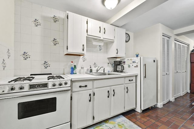 kitchen featuring white appliances, a sink, decorative backsplash, brick patterned flooring, and light countertops