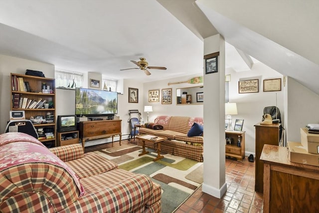 living area featuring a baseboard radiator, ceiling fan, and brick floors
