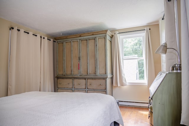 bedroom featuring light hardwood / wood-style floors and a baseboard radiator