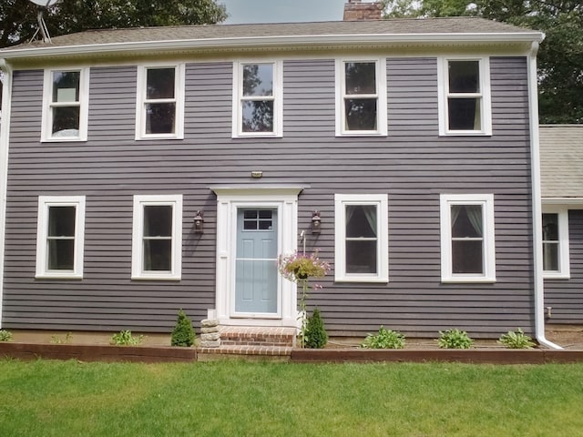 colonial inspired home featuring a front yard