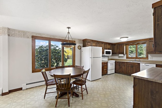 kitchen featuring white appliances, baseboards, light floors, baseboard heating, and a sink